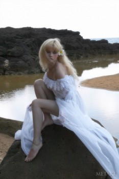 Lovely blonde is white dress is enjoying solo in water
