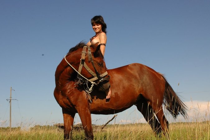 Naked brunette rides a horse in the field. photo 9