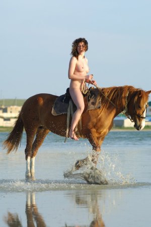 Cutie rides a horse without any clothes on her body. photo 6