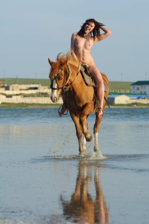 Cutie rides a horse without any clothes on her body. photo 18