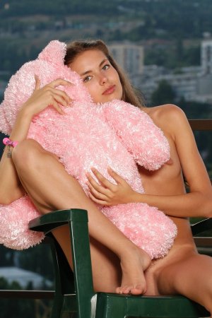 Sweetie has fun with a pink bear on the balcony. photo 1