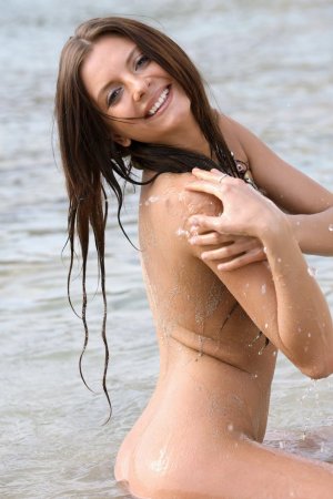 Brunette rubs her naked body with sand on the beach. photo 10