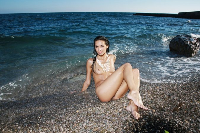 Gorgeous brunette is getting naked in the sea photo 2