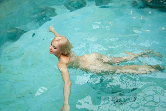 Naked blondie swims in the outdoor pool. photo 1