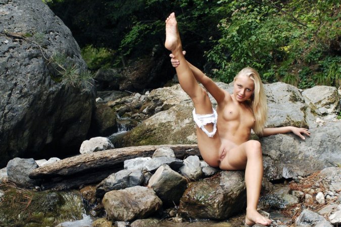 Blondie squats to tease pussy in the rocks. photo 1