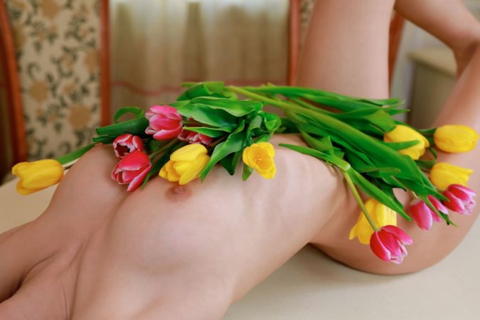 Brunette covers her pussy with flowers and hands photo 2