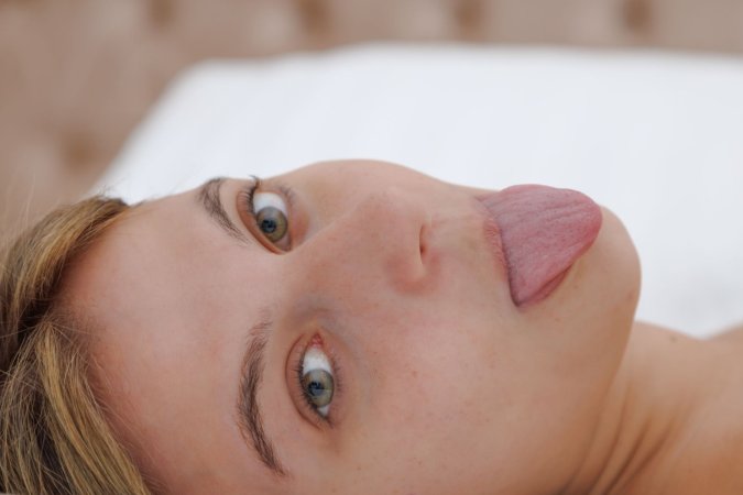 Zoelie plays on her bed in a striptease photo 14